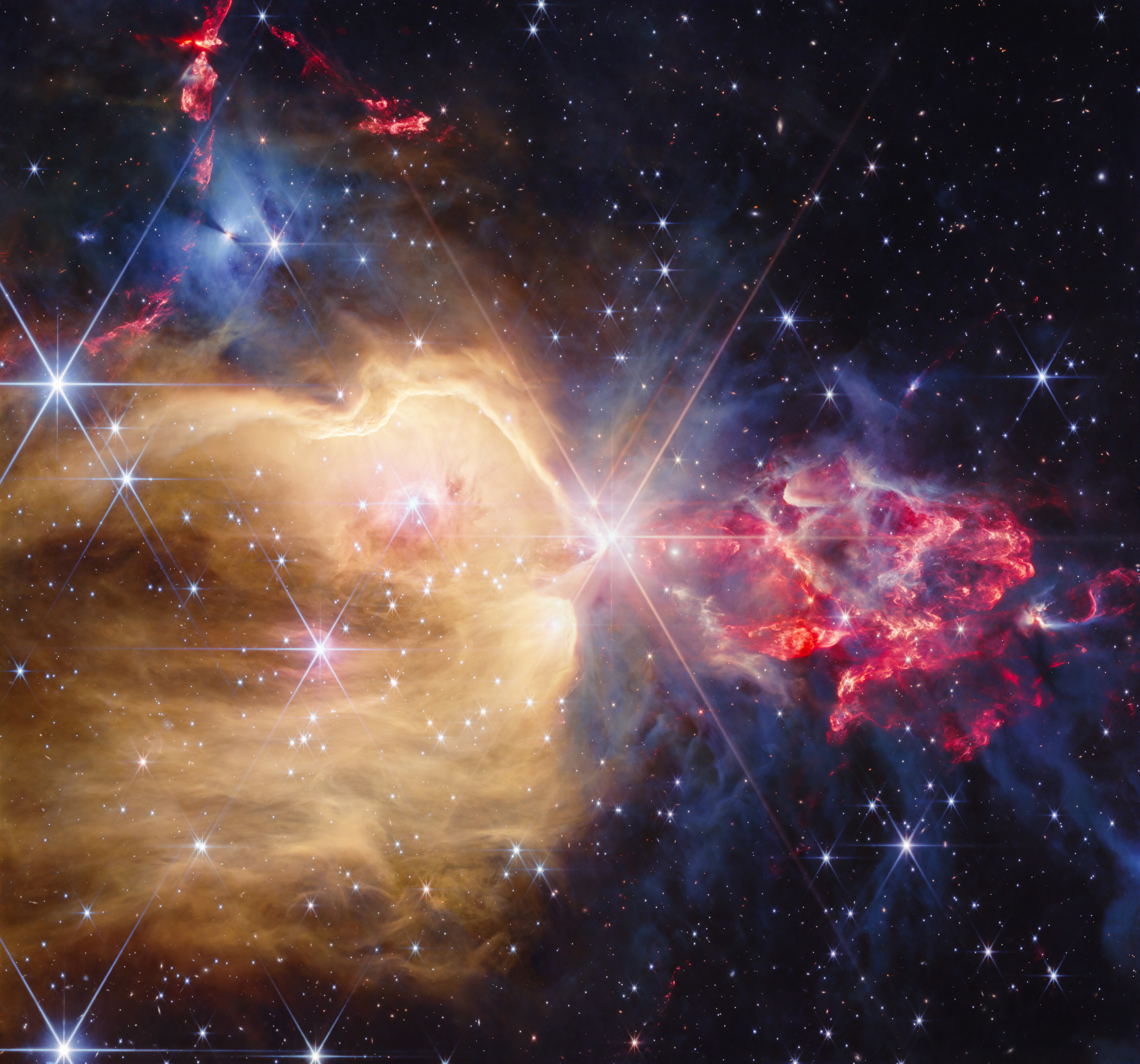 Golden and red gas clouds surround bright young stars in the Webb image of NGC 7129.