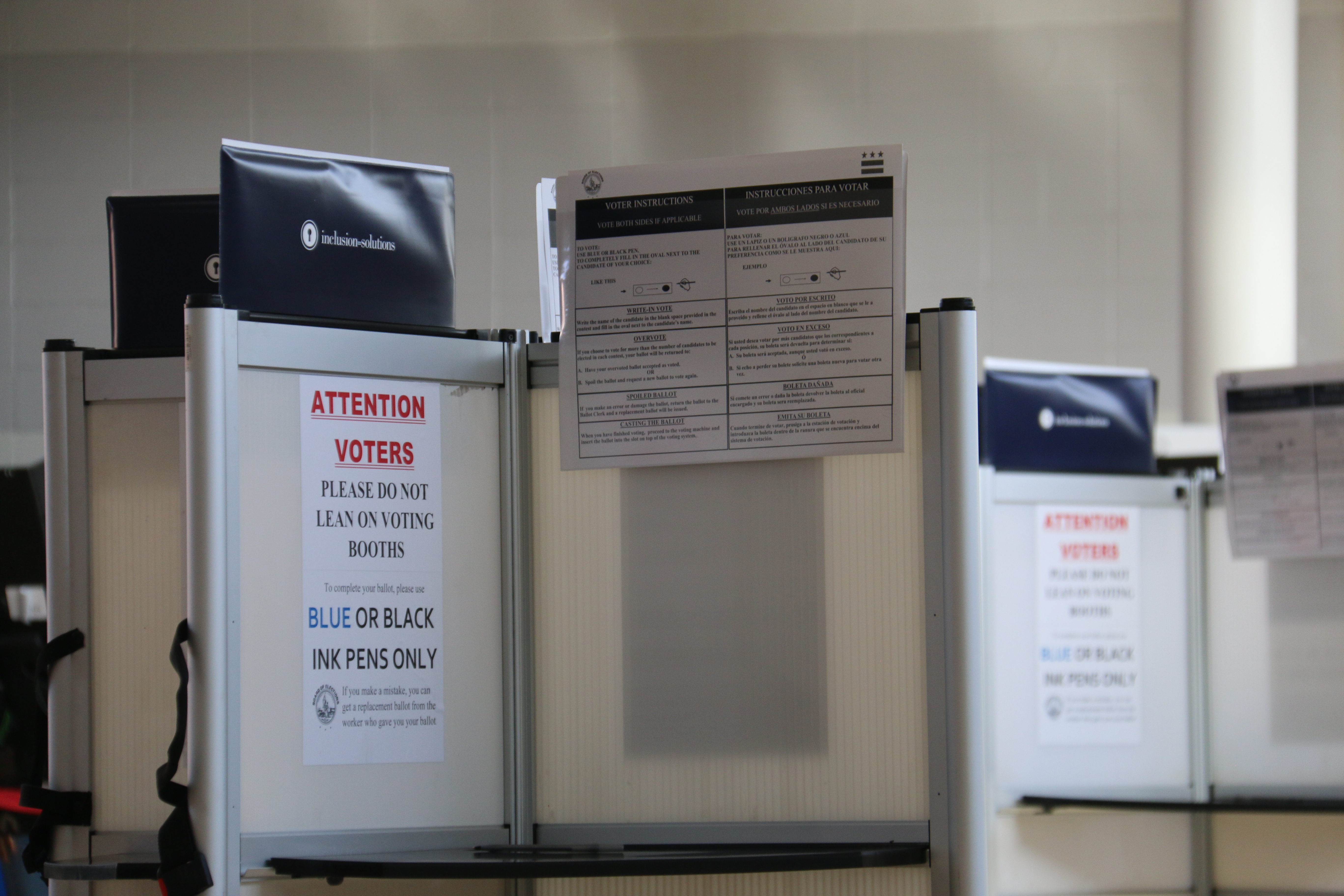 Unoccupied voting booths with instruction signs at a Washington, D.C. polling station in 2024.
